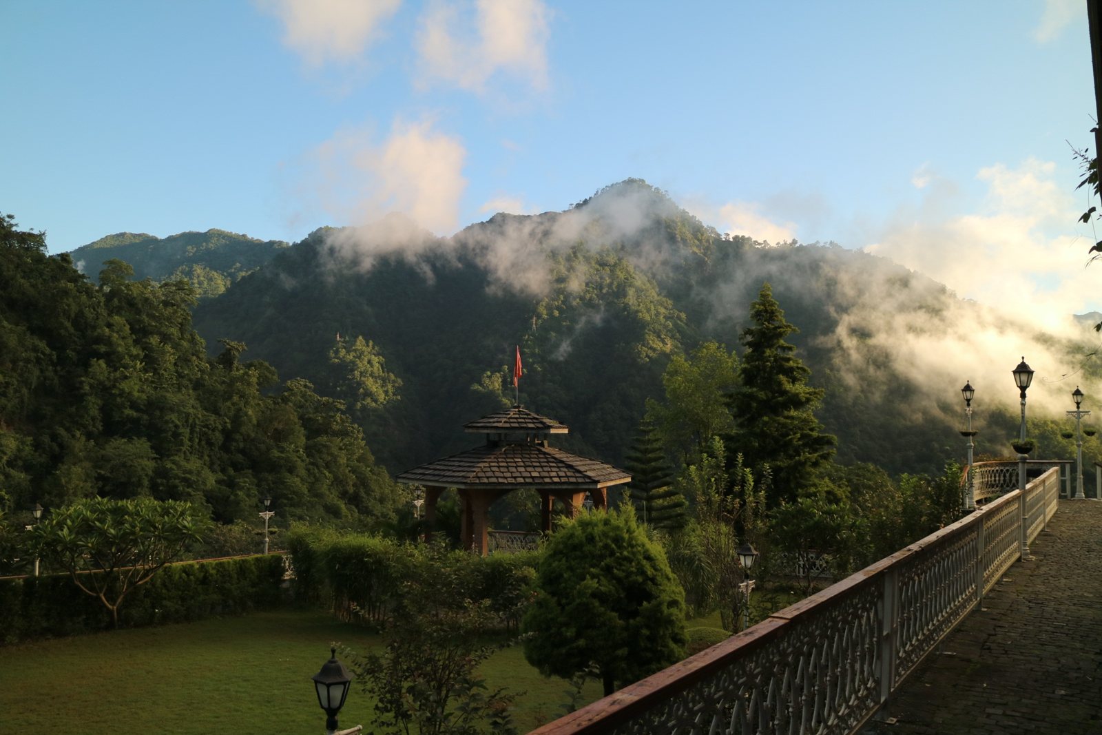 Garden and gazebo below misty green mountains