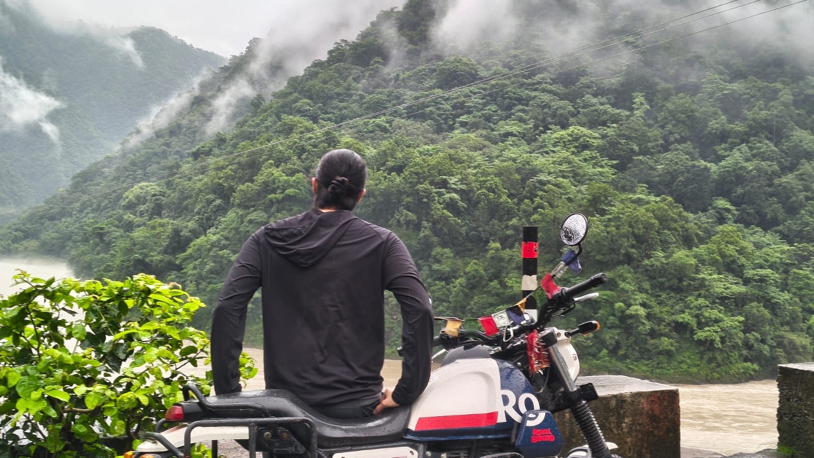 Sitting on a Royal Enfield looking at misty mountains